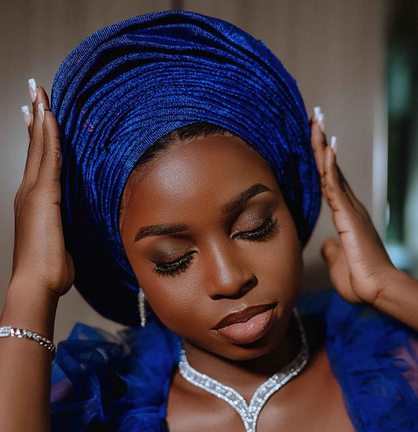 Bridal makeup by Aylustre, with a sculptural cobalt blue gele
